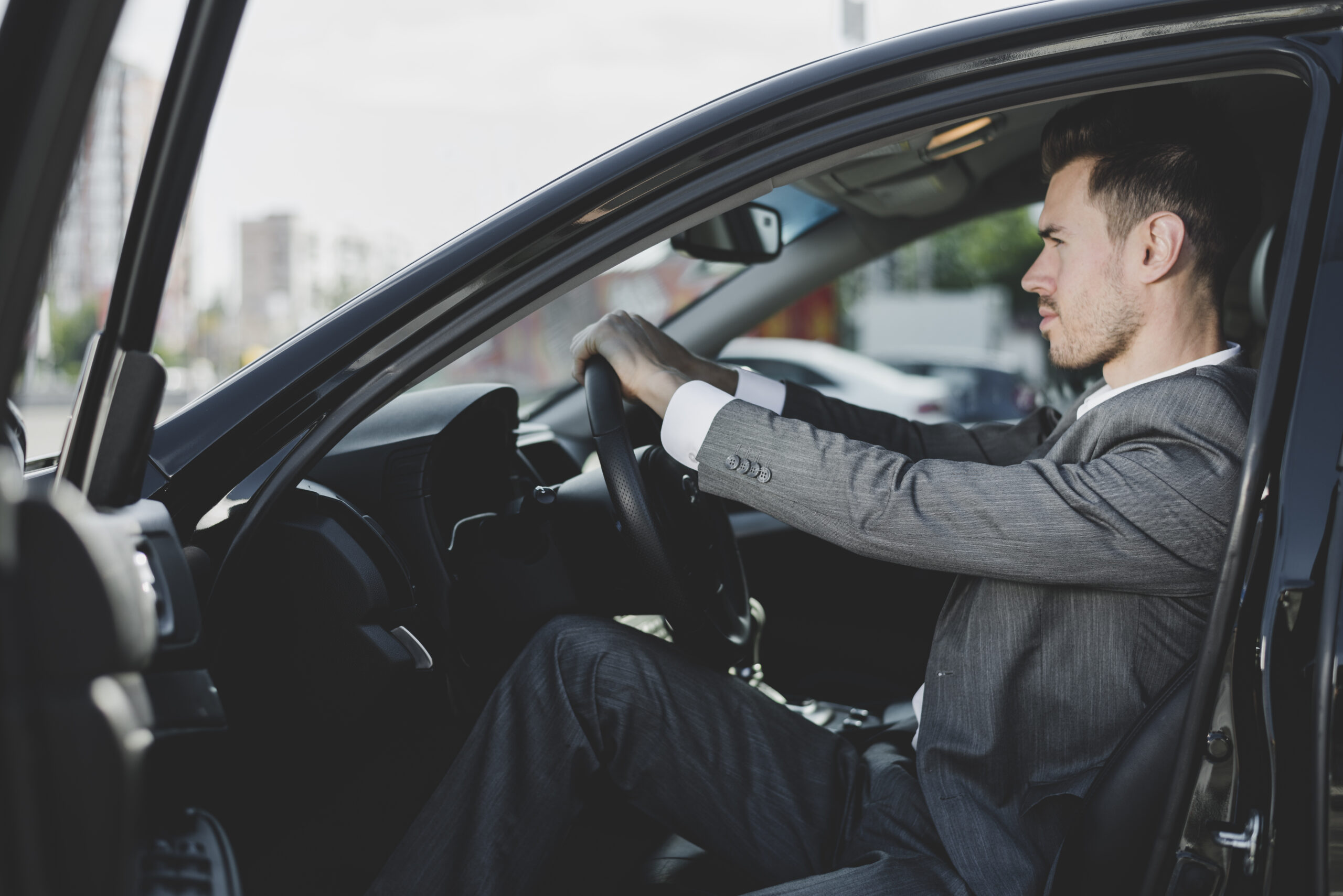 close-up-man-sitting-car-holding-steering-wheel